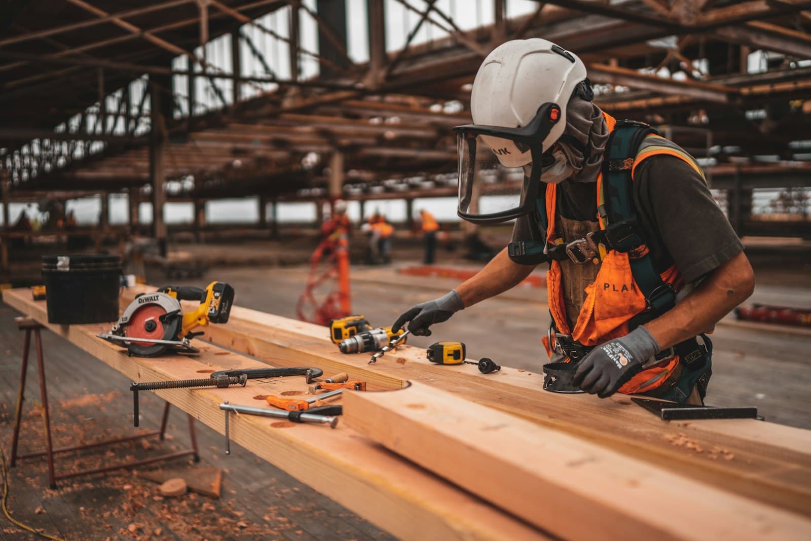 Vakman op de bouwplaats met gereedschap voor houtconstructie.