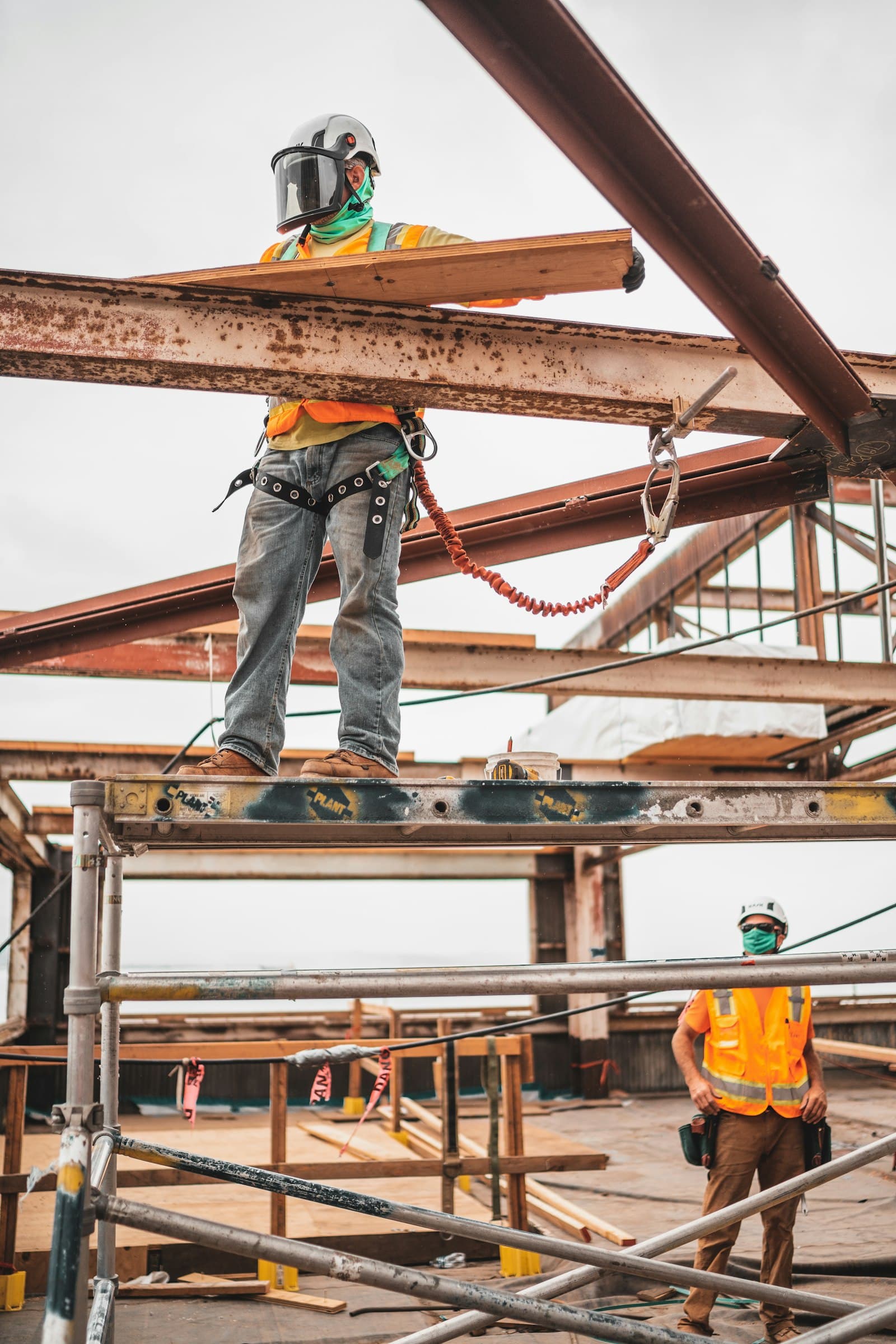 Bouwvakkers op een stalen constructie tijdens ruwbouw.